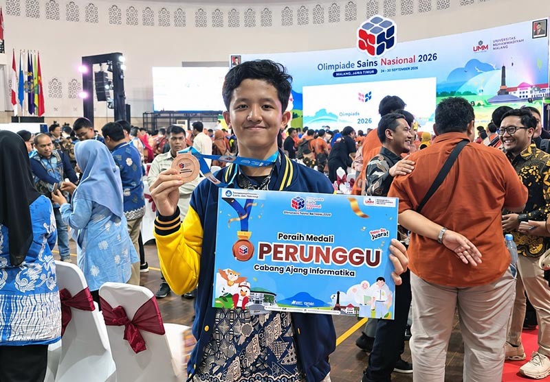 Muhammad Hanif Nazmi Oktana, siswa SMA Al Hikmah Surabaya, menunjukkan Medali Perunggu dan papan penghargaan yang berhasil diraihnya pada ajang Olimpiade Sains Nasional (OSN) Tingkat Nasional 2026 bidang Informatika yang diselenggarakan di Universitas Muhammadiyah Malang (UMM). (FOTO : Istimewa/Novita)