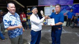 Sekretaris DPC Partai Demokrat Tanjab Barat Mukhtar AB bersama Syarifuddin ketua Bappilu menyerahkan Tropi dan Uang Pembinaan ke Ketua Tim Gasing Parit Lapis. FOTO : Dok Demokrat