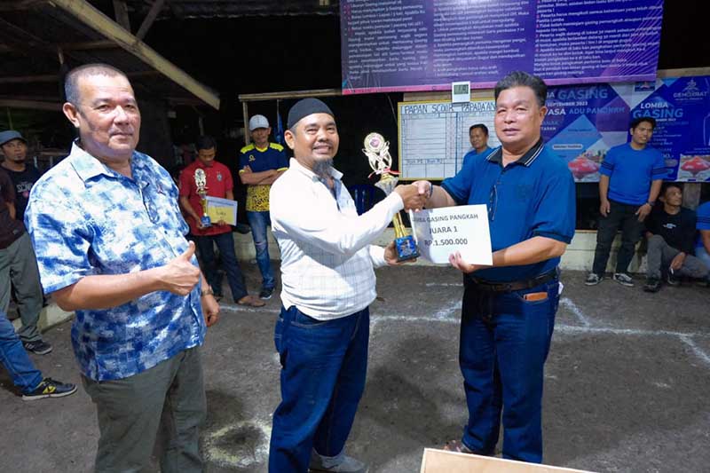 Sekretaris DPC Partai Demokrat Tanjab Barat Mukhtar AB bersama Syarifuddin ketua Bappilu menyerahkan Tropi dan Uang Pembinaan ke Ketua Tim Gasing Parit Lapis. FOTO : Dok Demokrat