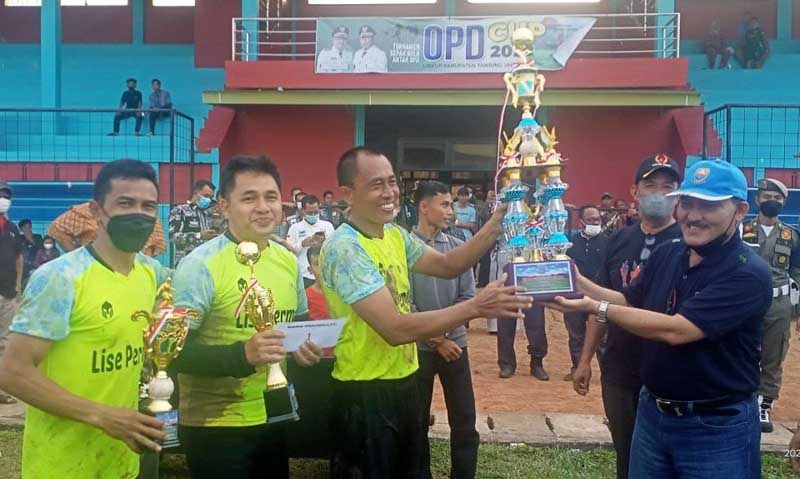 Husaini Kaptem Tim Kecamatan Tungkal Ilir menerima Trofi bergilir OPD Cup yang diserahkan H Mulyadi Staf Ahli, Kamis (24/3/22). FOTO : Lintastungkal