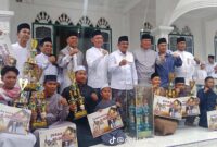 Para pemenang Festival Pawai Takbiran Hari Raya Idul Fitri 1447 H / 2026 M berfoto bersama jajaran pejabat pemerintahan daerah dan tokoh masyarakat usai menerima piala serta hadiah uang pembinaan secara simbolis di halaman Masjid Agung Al-Istiqamah, Kuala Tungkal. (FOTO: Dok. Istimewa Lintastungkal)