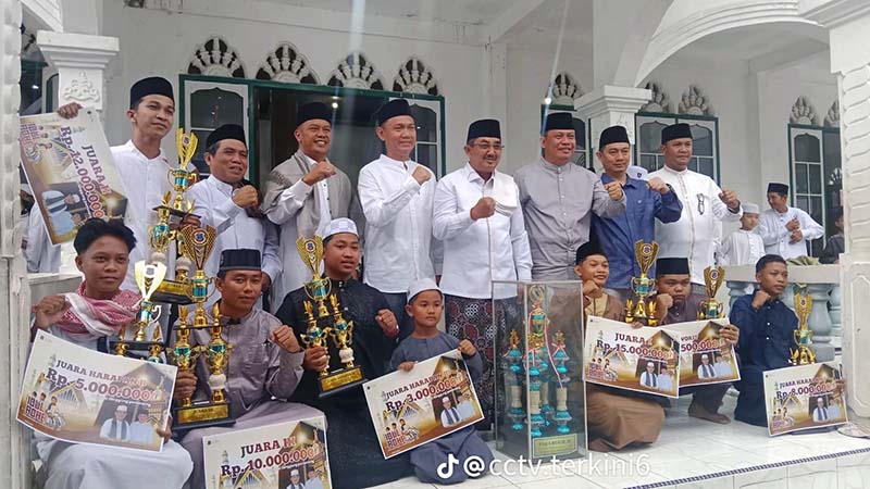 Para pemenang Festival Pawai Takbiran Hari Raya Idul Fitri 1447 H / 2026 M berfoto bersama jajaran pejabat pemerintahan daerah dan tokoh masyarakat usai menerima piala serta hadiah uang pembinaan secara simbolis di halaman Masjid Agung Al-Istiqamah, Kuala Tungkal. (FOTO: Dok. Istimewa Lintastungkal)