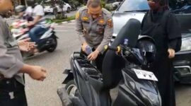 Kapolsek Jelutung IPTU Al Imron Saat Menunag BBM ke Tangki Motor Seorang Ibu Guru yang Kehabisan BBM. FOTO : ISt