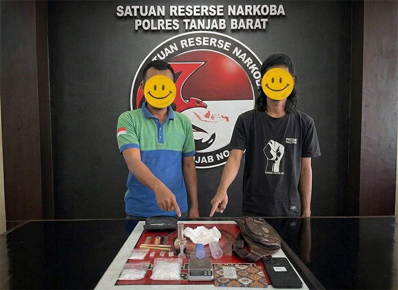 BARANG BUKTI & PELAKU: (Dari kiri ke kanan) MR (38) dan SI (29) saat diamankan di Mapolres Tanjung Jabung Barat bersama sejumlah barang bukti narkotika jenis sabu, alat hisap (bong), timah rokok, serta ponsel yang digunakan untuk bertransaksi. Keduanya diringkus tim gabungan Polsek Tungkal Ulu setelah terendus menjalankan bisnis haram yang dikendalikan dari balik jeruji besi. (FOTO : Dok. Humas Res Tanjabbbar)