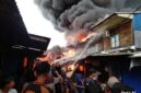 MEMBARA: Kobaran api disertai kepulan asap tebal menghanguskan puluhan bangunan di Pasar Teluk Nilau, Kecamatan Pengabuan, Tanjab Barat, Jumat (1/5). Sebanyak 70 KK dilaporkan terdampak akibat musibah ini. (FOTO : Humas Res TJB)