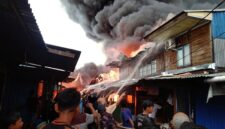 MEMBARA: Kobaran api disertai kepulan asap tebal menghanguskan puluhan bangunan di Pasar Teluk Nilau, Kecamatan Pengabuan, Tanjab Barat, Jumat (1/5). Sebanyak 70 KK dilaporkan terdampak akibat musibah ini. (FOTO : Humas Res TJB)