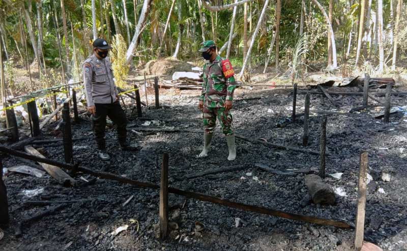 FOTO : Petugas Melakukan Pemeriksaan di Rumah warga di RT 05 Dusun Tanjung Baru Desa Sungai Jering, Kec. Pengabuan, Kabupaten Tanjab Barat yang hangus terbakar, Kamis (25/02/21).