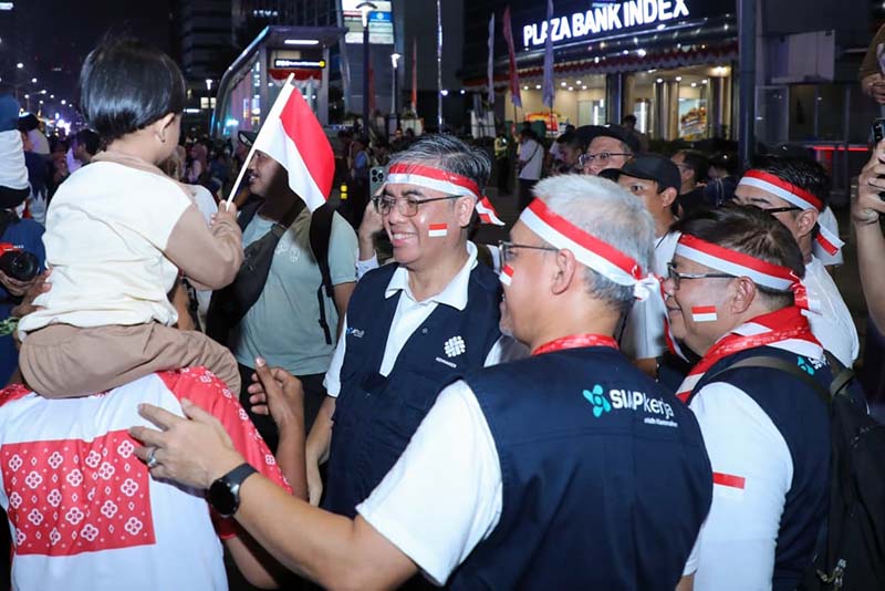Menaker Yassierli menyapa langsung masyarakat yang antusias menyaksikan Karnaval HUT ke-81 RI di sepanjang rute Monas hingga Bundaran HI (17/8/2026). (Foto: Humas Kemnaker)