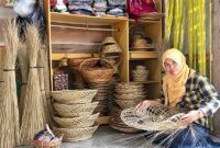  Siti Rohani menunjukkan proses pembuatan piring dan keranjang anyaman berbahan dasar lidi kelapa sawit. Usaha Difa Kreasi yang dirintisnya kini menjadi salah satu UMKM unggulan mitra binaan Pertamina Patra Niaga Kilang Dumai. (FOTO : Dok. Pertamina)