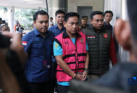 Ketua Ombudsman RI, Hery Susanto berjalan menuju mobil tahanan di gedung Kejaksaan Agung, Jakarta, Kamis (16/4/2026). (FOTO : dok. CNBC Indonesia/Faisal Rahman)