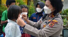 Kasat Binmas Polresta Jambi Kompol Mardonna Lamtio Memasang dan Membagikan Masker Saat Vaksinasi Siswa SDN 64 Kota Jambi, Kamis (10/2/22). FOTO : Humas PMJ.