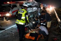 Petugas kepolisian bergerak cepat mengevakuasi korban sesaat setelah kecelakaan maut terjadi di Tol Pekanbaru-Dumai KM 46+200, Sabtu (6/6/2026) sekitar pukul 04.00 WIB. Insiden tragis ini diduga dipicu oleh pengemudi minibus yang mengalami microsleep. (Foto: Dok. Ditlantas Polda Riau)
