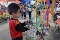 Seorang Anak Membeli Lato-Lato di Pasar Malam Alun-Alun Kota Kuala Tungkal. FOTO : Ngah/LT