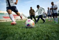 SIMBOLIK: Gubernur Jambi, Al Haris, melakukan tendangan bola pertama dalam laga eksibisi antara Pemprov Jambi melawan DPRD Provinsi Jambi sebagai tanda dibukanya Liga 4 Jambi 2026 di Stadion Swarnabhumi, Pijoan, Jumat (10/4). Kompetisi ini menjadi ajang pencarian talenta muda sepak bola Jambi untuk bersaing di level nasional. (FOTO : Dok. Istimewa)