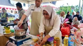Kepala BKPSDM Kabupaten Tanjung Jabung Barat, Saldi, S.H. (kiri) peserta (nomor meja 33) bersama staf sedang kompak mengolah menu masakan dalam Lomba Masak Serba Ikan (GEMARIKAN) yang digelar di halaman Kantor Bupati Tanjung Jabung Barat, Rabu (12/8/2026). (FOTO : Dok. BKPSDM TJB)