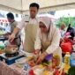 Kepala BKPSDM Kabupaten Tanjung Jabung Barat, Saldi, S.H. (kiri) peserta (nomor meja 33) bersama staf sedang kompak mengolah menu masakan dalam Lomba Masak Serba Ikan (GEMARIKAN) yang digelar di halaman Kantor Bupati Tanjung Jabung Barat, Rabu (12/8/2026). (FOTO : Dok. BKPSDM TJB)