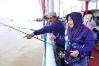 Bupati Tanjab Barat Anwar Sadat didampingi istri, Hj. Fadhilah Sadat, memantau langsung jalannya Lomba Mancing Semarak HUT RI dan HUT Kabupaten Tanjab Barat di area ikonik WFC Kuala Tungkal, Kamis (6/8/2026). (Foto: Istimewa)