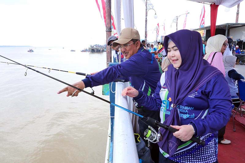 Bupati Tanjab Barat Anwar Sadat didampingi istri, Hj. Fadhilah Sadat, memantau langsung jalannya Lomba Mancing Semarak HUT RI dan HUT Kabupaten Tanjab Barat di area ikonik WFC Kuala Tungkal, Kamis (6/8/2026). (Foto: Istimewa)