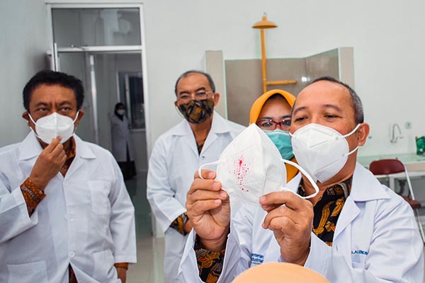 Kepala BSKJI Doddy Rahadi disaksikan oleh Kepala Badan Pengembangan Sumber Daya Manusia Industri (BPSDMI) Arus Gunawan (kiri) serta Kepala BBT Wibowo Dwi Hartoto (tiga dari kanan) melihat hasil pengujian masker saat meninjau lab pengujian Masker N95 di Gedung BBT, Bandung, 18 Maret 2021.(FOTO : LT/kemenperin.go.id)