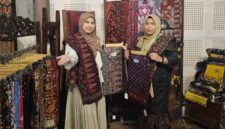 SINERGI PELESTARIAN BUDAYA: Ketua Persit KCK Cabang XXIII Kodim 0415/Jambi, Ny. Chichi Putra Negara (kiri), bersama Ny. Ruslaini Fadli (kanan) menunjukkan kain Batik Jambi motif unggulan di Booth 65 pameran 