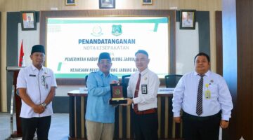 SINERGI HUKUM: Bupati Tanjung Jabung Barat, Anwar Sadat (kedua kiri), menyerahkan plakat kepada Kepala Kejaksaan Negeri Tanjab Barat usai penandatanganan perpanjangan MoU di Aula Kantor Inspektorat, Rabu (4/3). Kerja sama ini difokuskan pada pendampingan hukum guna mengawal proyek-proyek strategis daerah dari potensi penyimpangan. [FOTO : Dok. PROKOPIM]