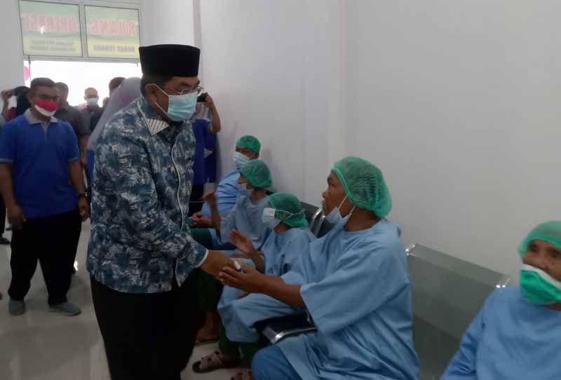 Bupati Tanjung Jabung Barat H. Anwar Sadat menyalami Warga yang akan menjalani Operasi Mata, Minggu (21/8/22). FOTO : Ist