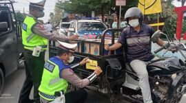 Petugas dari Satlantas Polres Tanjung Jabung Barat memasang Stiker Nomor bantuan Polisi ke salah satu kendaraan, Selasa (1/3/22). FOTO : Lintastungkal