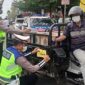 Petugas dari Satlantas Polres Tanjung Jabung Barat memasang Stiker Nomor bantuan Polisi ke salah satu kendaraan, Selasa (1/3/22). FOTO : Lintastungkal