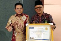 Sembari pegang Piagam penghargaan, Ketua PA Kuala Tungkal Zakaria Ansori foto bersama Sekjen Mahkamah Agung Prof DR Hasbi Hasan MA. FOTO : Istimewa