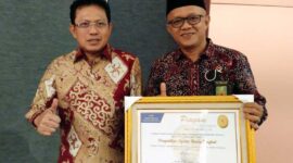 Sembari pegang Piagam penghargaan, Ketua PA Kuala Tungkal Zakaria Ansori foto bersama Sekjen Mahkamah Agung Prof DR Hasbi Hasan MA. FOTO : Istimewa