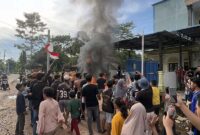 AMUK MASSA: Ratusan warga Panipahan menyemut di depan sebuah bangunan yang diduga menjadi sarang narkoba, Jumat (10/04). Massa yang emosi membakar sejumlah kendaraan dan merusak bangunan sebagai bentuk protes atas maraknya peredaran sabu di wilayah mereka. (FOTO : Dok. Istimewa)