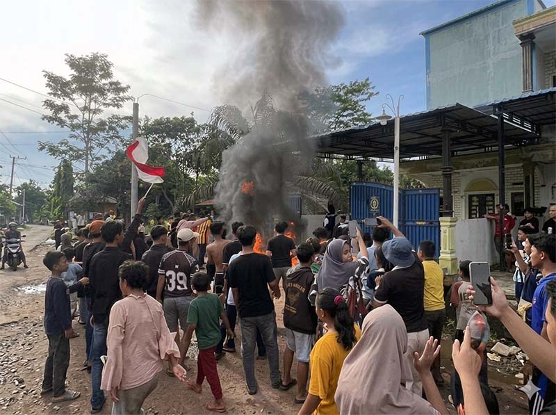 AMUK MASSA: Ratusan warga Panipahan menyemut di depan sebuah bangunan yang diduga menjadi sarang narkoba, Jumat (10/04). Massa yang emosi membakar sejumlah kendaraan dan merusak bangunan sebagai bentuk protes atas maraknya peredaran sabu di wilayah mereka. (FOTO : Dok. Istimewa)