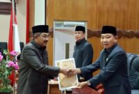 Bupati Tanjung Jabung Barat H. Anwar Sadat (kiri) menyerahkan berkas tanggapan eksekutif kepada Ketua DPRD Tanjung Jabung Barat Hamdani (kanan) disaksikan Wakil Bupati H. Katamso (tengah) dalam Rapat Paripurna III di Ruang Rapat Paripurna DPRD Tanjung Jabung Barat, Jumat (5/6). Forum ini menyepakati pembentukan Pansus untuk mengoptimalkan pembahasan empat Ranperda daerah. (FOTO : Dok. Prokopim)
