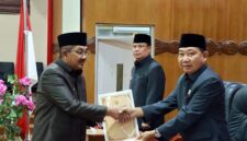 Bupati Tanjung Jabung Barat H. Anwar Sadat (kiri) menyerahkan berkas tanggapan eksekutif kepada Ketua DPRD Tanjung Jabung Barat Hamdani (kanan) disaksikan Wakil Bupati H. Katamso (tengah) dalam Rapat Paripurna III di Ruang Rapat Paripurna DPRD Tanjung Jabung Barat, Jumat (5/6). Forum ini menyepakati pembentukan Pansus untuk mengoptimalkan pembahasan empat Ranperda daerah. (FOTO : Dok. Prokopim)