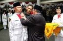Bupati H. Anwar Sadat, menyematkan Lencana Merah Putih Garuda secara simbolis kepada pemimpin upacara dalam prosesi Pengukuhan 45 Anggota Pasukan Pengibar Bendera Pusaka (Paskibraka) Kabupaten Tanjung Jabung Barat Tahun 2026 di Halaman Rumah Dinas Jabatan Bupati, Sabtu (15/8/2026). (FOTO : Dok. Prokopim)
