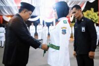Bupati Tanjab Barat Drs H Anwar Sadat, M. Ag kenakan kendit kepada Anggota Paskibraka, Selasa (15/8/23). FOTO : FM