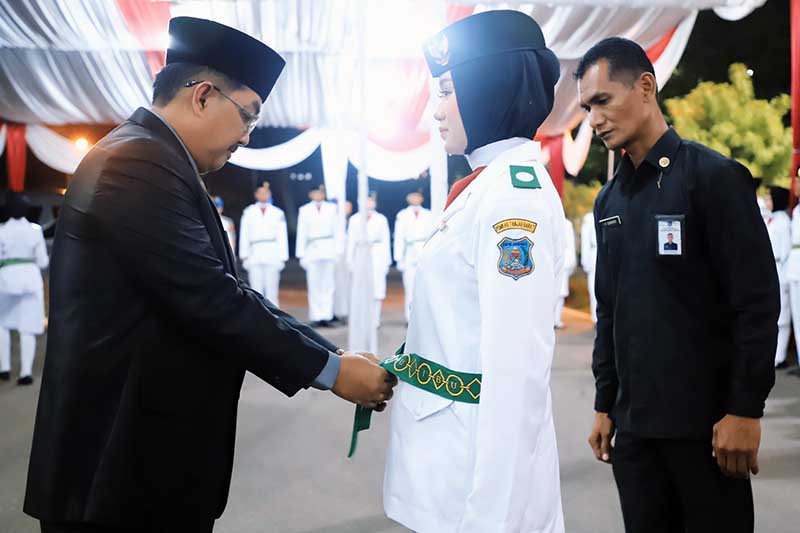Bupati Tanjab Barat Drs H Anwar Sadat, M. Ag kenakan kendit kepada Anggota Paskibraka, Selasa (15/8/23). FOTO : FM