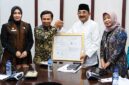 Bupati H. Anwar Sadat, bersama Kepala Kanwil Kemenkumham Jambi, Jonson Siagian, dan Kepala BRIDA Provinsi Jambi, Sri Argunaini, menunjukkan Sertifikat Indikasi Geografis (IG) untuk komoditas Pinang Betara di Ruang Rapat Bupati. Sertifikasi ini menjadi momentum penting dalam melindungi hak kekayaan intelektual komunal sekaligus membuka peluang ekonomi baru bagi petani lokal. (Foto: Dok. Humas/Pemkab Tanjab Barat)