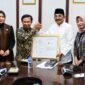 Bupati H. Anwar Sadat, bersama Kepala Kanwil Kemenkumham Jambi, Jonson Siagian, dan Kepala BRIDA Provinsi Jambi, Sri Argunaini, menunjukkan Sertifikat Indikasi Geografis (IG) untuk komoditas Pinang Betara di Ruang Rapat Bupati. Sertifikasi ini menjadi momentum penting dalam melindungi hak kekayaan intelektual komunal sekaligus membuka peluang ekonomi baru bagi petani lokal. (Foto: Dok. Humas/Pemkab Tanjab Barat)
