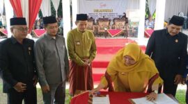 Bupati Muaro Jambi Hj. Masnah Busro Ketika Menandatangai Berita Acara Pelantikan Ketua dan Pengurus PKK Desa se Kacamatan Sungai Gelam, Senin (16/5/22). FOTO : Noval