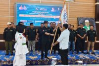 Ketua SMSI Provinsi Jambi Muhtadi Putra Nusa menyerahkan Bendera Pataka ke Ketua SMSI Tanjab Barat Ikmal Madiansyah usai pengukuhan. FOTO : LT