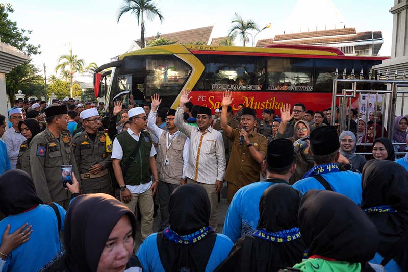 Bupati Tanjung Jabung Barat, Drs. H. Anwar Sadat, M.Ag. (tengah melambaikan tangan), menyapa dan melepas keberangkatan 105 jemaah haji Kelompok Terbang (Kloter) 24 di Kuala Tungkal, Selasa (19/5/2026). (Foto: Dok. Istimewa/Prokopim Tanjab Barat)