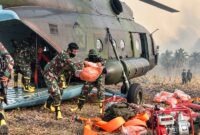 Personel TNI gabungan menurunkan perlengkapan pemadam kebakaran dari helikopter angkut saat tiba di wilayah rawan Karhutla Jambi. (FOTO : Dok. PENREM042GAPU0