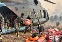 Personel TNI gabungan menurunkan perlengkapan pemadam kebakaran dari helikopter angkut saat tiba di wilayah rawan Karhutla Jambi. (FOTO : Dok. PENREM042GAPU0