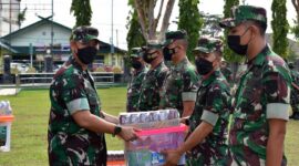 Kasrem 042/Gapu Kolonel Inf M. Yamin Dano Menyerahkan Bingkisan kepada perwakilan masing – masing Staf untuk selanjutnya diberikan kepada anggota yang berhak Pada Apel Pagi di Lapangan Apel Makorem, Senin (25/4/22). FOTO : PENREM