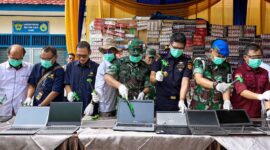 Kepala Kantor Bea Cukai Jambi, Dafit Kasianto (kanan baju hitam), dan sejumlah pejabat instansi terkait secara simbolis menghancurkan laptop bekas ilegal menggunakan palu saat pemusnahan Barang yang Menjadi Milik Negara (BMMN) di halaman Kantor Bea Cukai Jambi, Rabu (24/6/2026). (Foto: Penrem 042/Gapu)