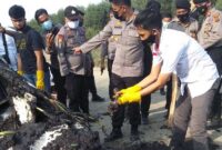 Anggota Polres Tanjab Timur Saat Memeriksa Bangkai Mobil dan Melihat Tulang Diduga Manusia di TKP Penemuan, Rabu (03/03/21). FOTO : Gt