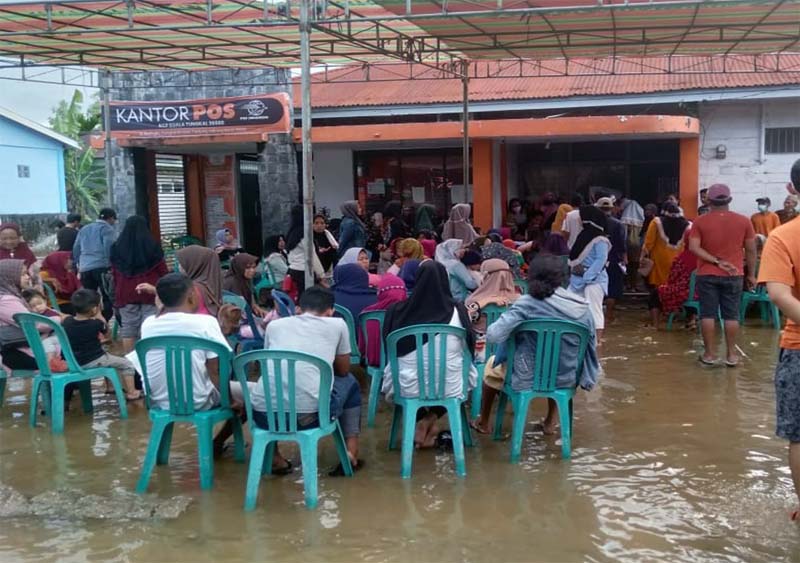 Keluarga Penerima Manfaat di Tanjung Jabung Barat saat mengambil bantuan sosial ditengah banjir pasang surut di Kantor Pos Cabang Kuala Tungkal, Kamis (24/11/22). FOTO : Bas/LT