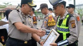 APRESIASI KINERJA: Kapolres Tanjab Barat AKBP M. Kuswicaksono, S.I.K., M.H., memberikan piagam penghargaan kepada salah satu personel dalam upacara Apel Jam Pimpinan di Mapolres Tanjab Barat, Senin (30/03/2026). Penghargaan ini diberikan atas dedikasi dan respons cepat personel dalam menindaklanjuti laporan masyarakat melalui layanan Call Center 110. (FOTO : Dok. Humas Res TJB)