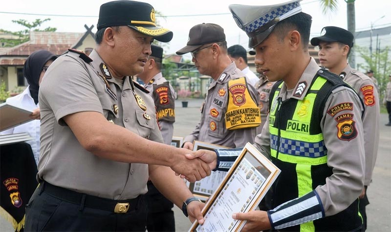 APRESIASI KINERJA: Kapolres Tanjab Barat AKBP M. Kuswicaksono, S.I.K., M.H., memberikan piagam penghargaan kepada salah satu personel dalam upacara Apel Jam Pimpinan di Mapolres Tanjab Barat, Senin (30/03/2026). Penghargaan ini diberikan atas dedikasi dan respons cepat personel dalam menindaklanjuti laporan masyarakat melalui layanan Call Center 110. (FOTO : Dok. Humas Res TJB)
